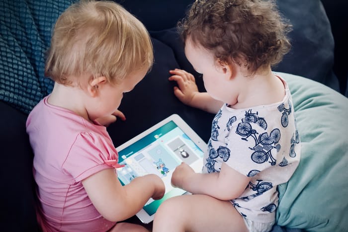 marketing to kids: two toddlers looking into an Ipad