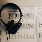 headphones over guitar chords on music sheet